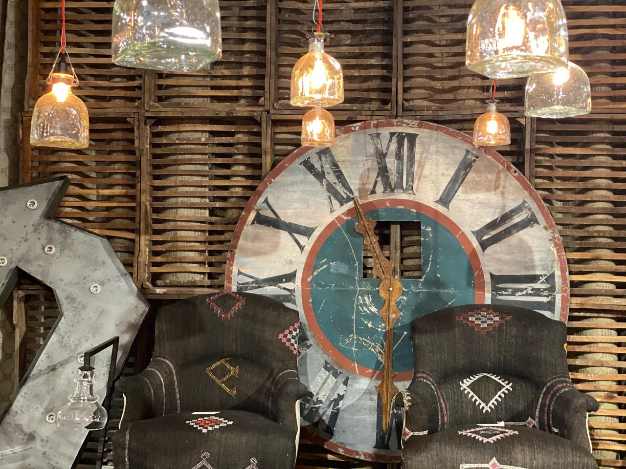 High Point Market showroom Fall 2020. Showroom with decorative clock and two armchairs. Cisco Home booth.